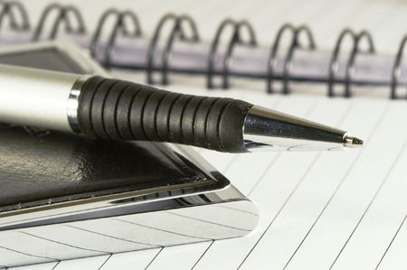 Silver-black pen lying on opened  notebookの写真素材