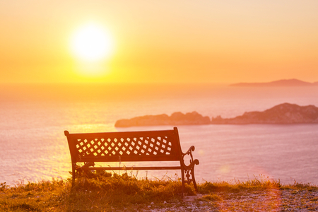 Bench on sea coast at sunriceの写真素材