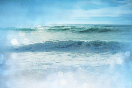 Blue wave on the beach. Blur background and sunlight spots. Peaceful natural background.の写真素材