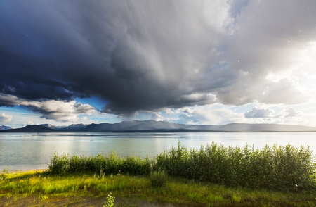 Serene scene by the mountain lake in Canada with reflection of the rocks in the calm water.の写真素材