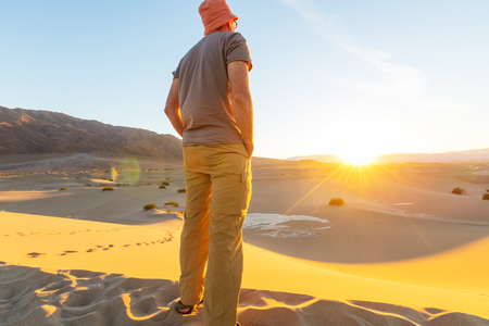 Hiker in sand desert. Sunrise time.の写真素材