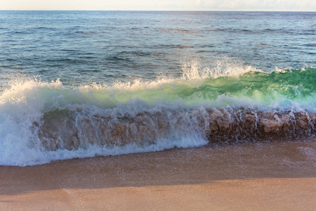 Blue wave on the beach. Blur background and sunlight spots. Peaceful natural background.の写真素材