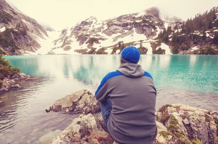 Hiker relaxing at serene mountain lakeの写真素材