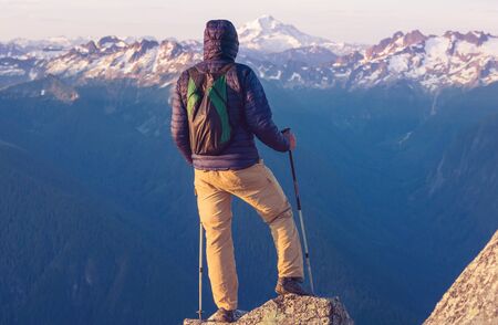 Man on the mountains cliff. Hiking scene.