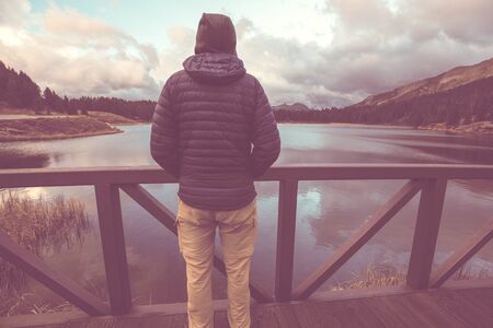 Hiker relaxing at serene mountain lake