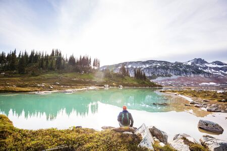 Hiker relaxing at serene mountain lakeの写真素材