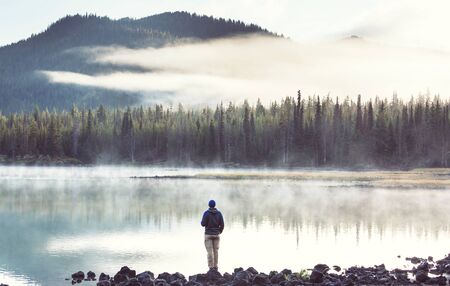 Hiker relaxing at serene mountain lakeの写真素材