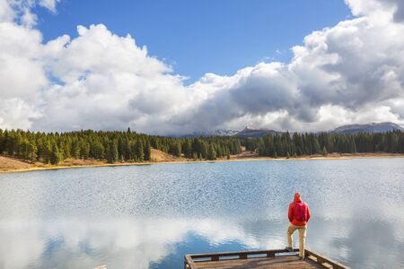 Hiker relaxing at serene mountain lakeの写真素材