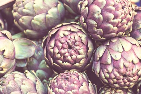 Fresh artichokes and tomatoes at farmers marketの写真素材