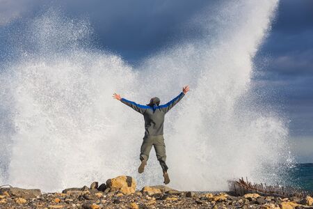 Man jumping in dramatic storm waves