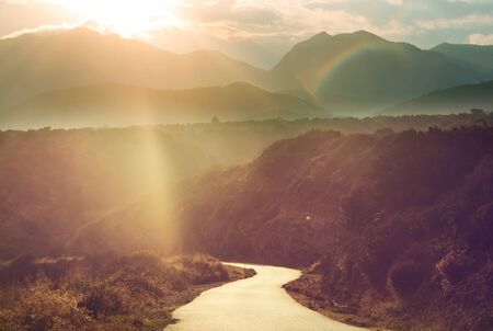 Scenic road in the mountains. Travel background. Man going on sunrise background.の写真素材