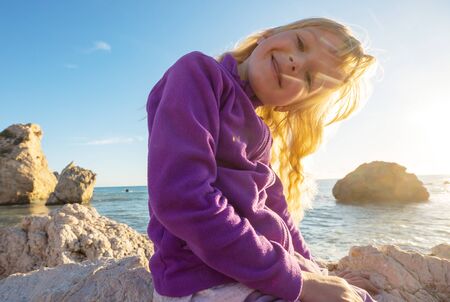 Happy little girl on the beach in sunny day