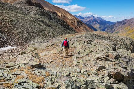Backpacker in hike in the autumn mountains