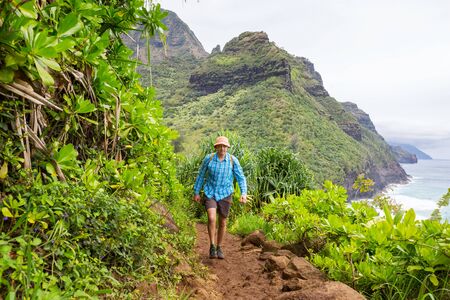 Hiker on the trail in green jungle, Hawaii, USAの写真素材