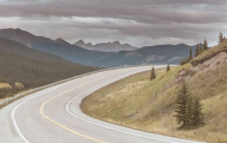 Scenic road in the mountains. Travel background. Man going on sunrise background.