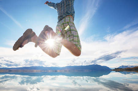 Jumping man above calm lake