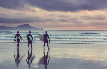 surfers on ocean  beach in New Zealand