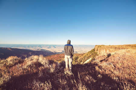 Man on the mountains cliff. Hiking scene.