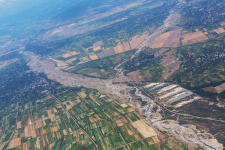 Aerial view of  green agricultural fields with a river