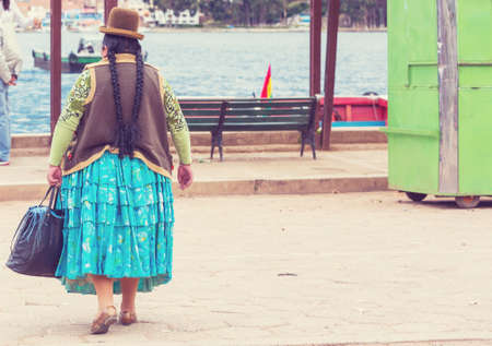 Woman in traditional dress in Titicaca quay in Boliviaの写真素材