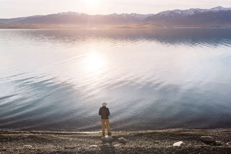 A man is resting at ease by the calm lake. Relaxation vacationの写真素材