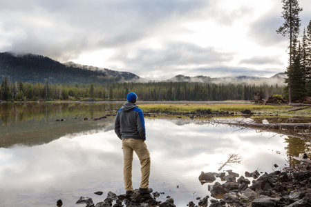 A man is resting at ease by the calm lake. Relaxation vacation
