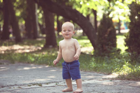 Little boy do his first steps  in summer parkの写真素材