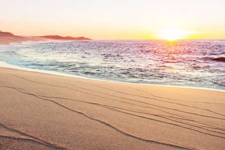 Beautiful sandy beach at sunrise for vacation background.