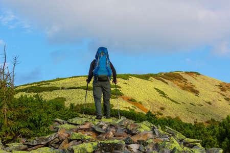 Backpacker in hike in the high mountains