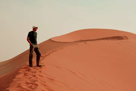 Hiker in sand desert. Sunrise time.の写真素材