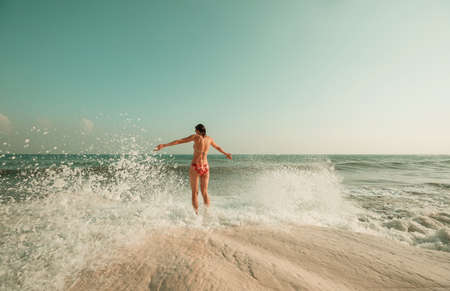 A young woman playing in the waves on a sea beach