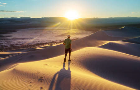 Hiker among sand dunes in the desertの写真素材