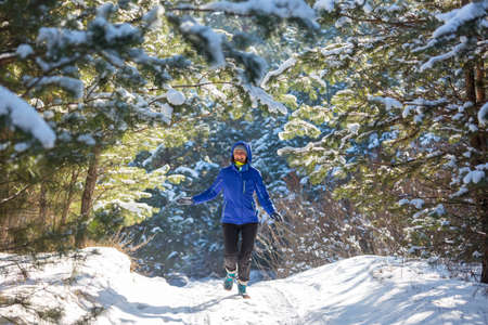 Young woman in  snowy forest  at sunny winter dayの写真素材