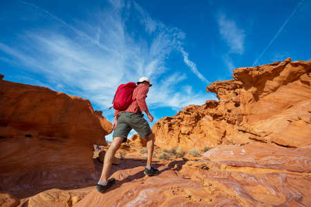Hiker inside a stone arch in the Nevada desert near Las Vegas, Nevada, USA