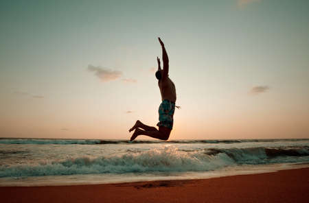 a man jumps between cliffs in the mountainsの写真素材