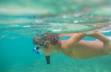a boy underwater snorkeling in the oceanの写真素材