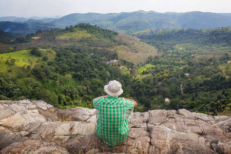 a tourist on a vantage point viewing the mountainous landscapesの写真素材