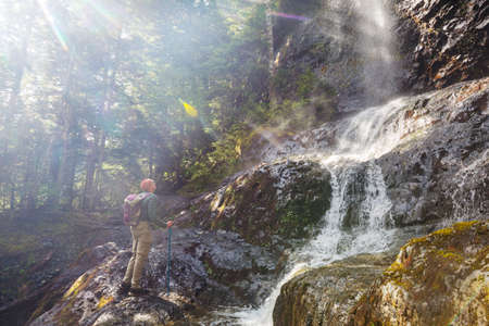 Hiker near  beautiful waterfall in Canadian mountainsの写真素材