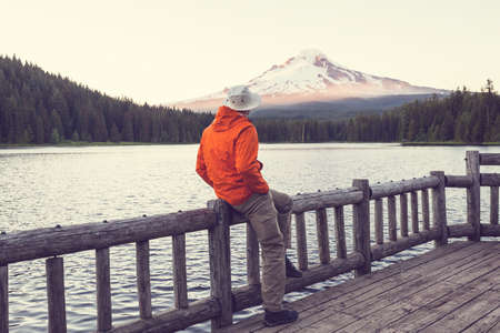 A man is resting at ease by the calm lake. Relaxation vacationの写真素材