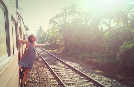 Yong woman  enjoying train ride from Ella to Kandy among tea plantations in the highlands of Sri Lankaの写真素材