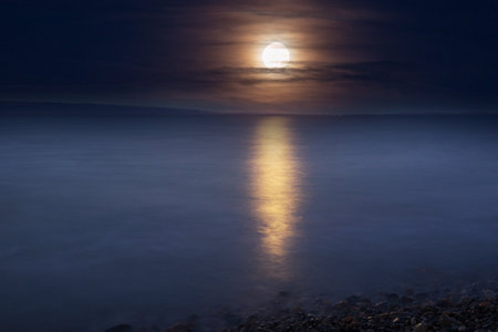 Full moon rising above lake
