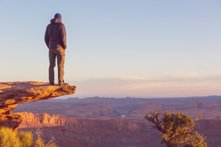 Man on the mountains cliff at sunrise. Hiking scene.の写真素材