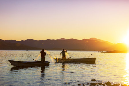 Fisnermen in boats on the lake at sunriseの写真素材