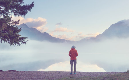 A man is resting at ease by the calm lake. Relaxation vacationの写真素材