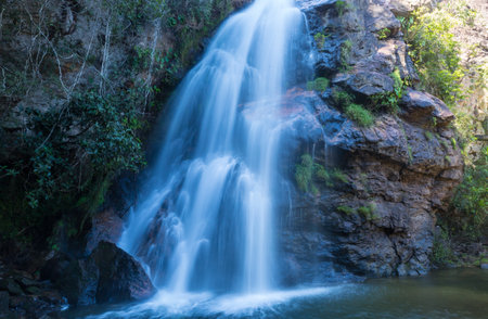 Tourist near amazing waterfall in Brazilian jungle