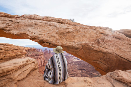Tourist in authentic poncho in the  Canyonlands National Park, Utah, USA.
