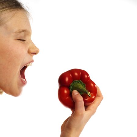 girl eating a red pepperの写真素材