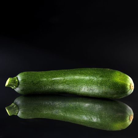 green courgette (black background, reflection)の写真素材