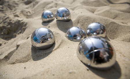 close-up of metal boccie balls in the sand