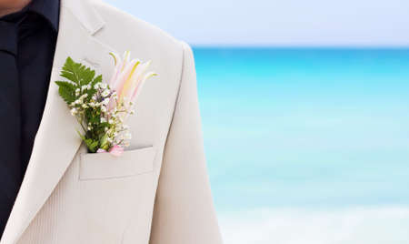 Groom's wedding suit with boutonniere made of flower and green leaves